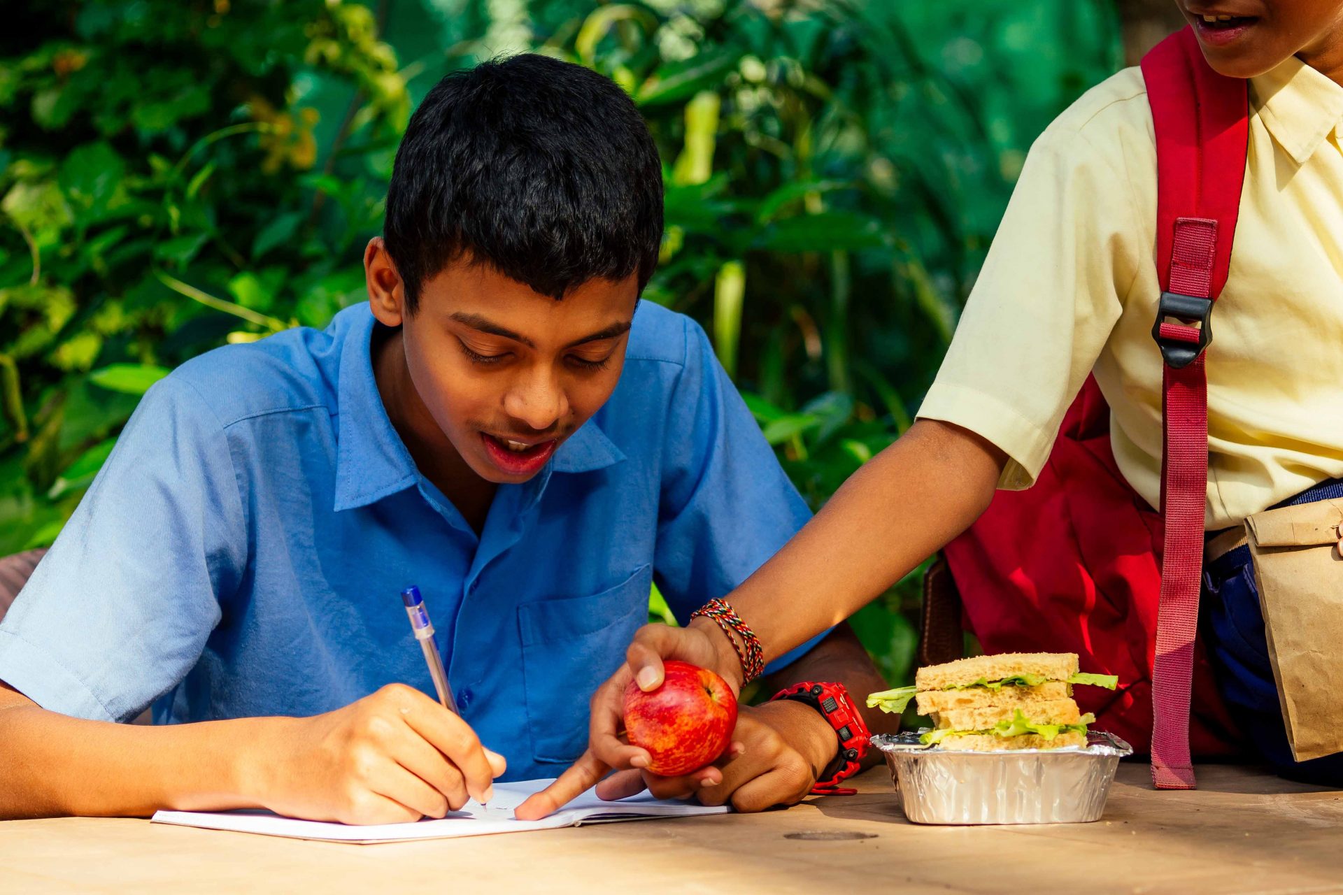 indian-school-boy-writing-on-notepad-doing-homewor-2022-05-01-23-21-06-utc